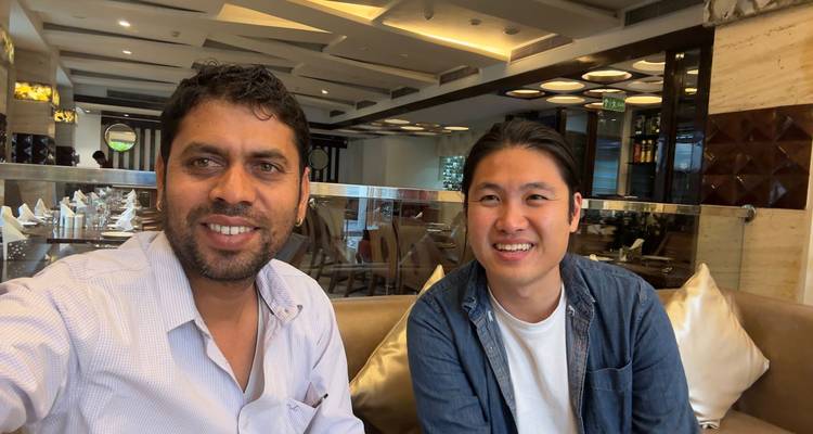 Zwei Männer lächeln in einem Restaurant.