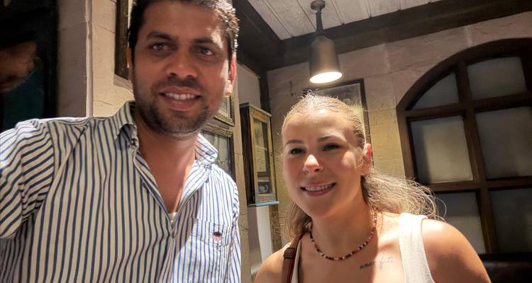 Zwei Personen lächeln drinnen in die Kamera.