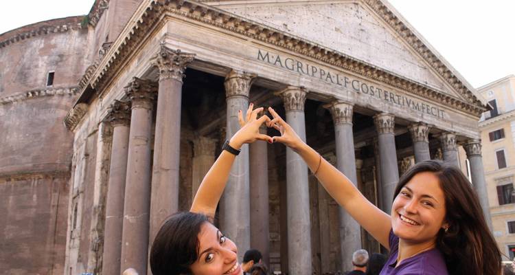 Deux personnes faisant des formes de cœur avec leurs mains devant le Panthéon.