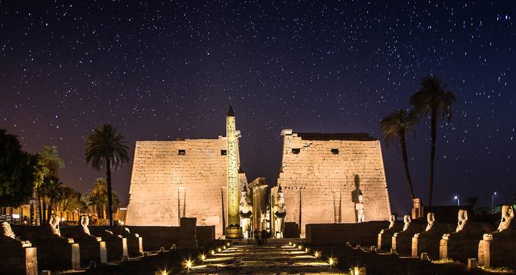 Luxor-Tempel nachts beleuchtet unter einem sternenklaren Himmel.