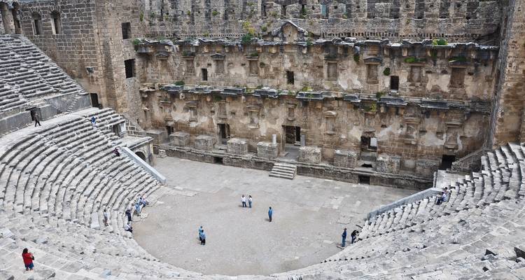 Romeinse theaterruïnes met toeristen die binnen aan het verkennen zijn.