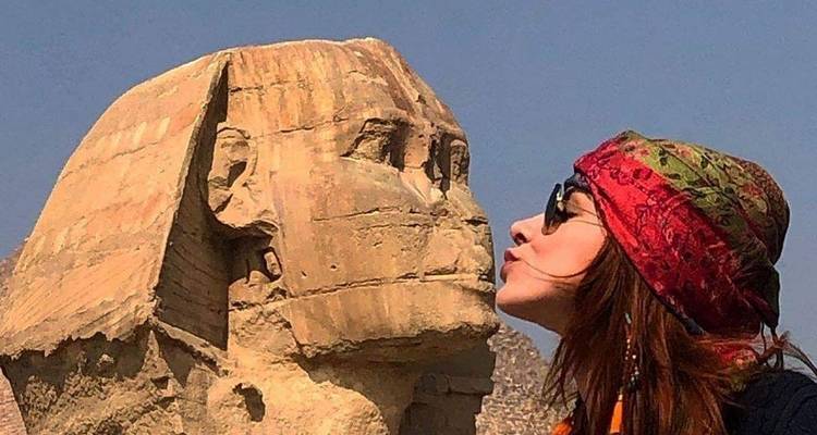 Personne interagissant de manière ludique avec le Sphinx.