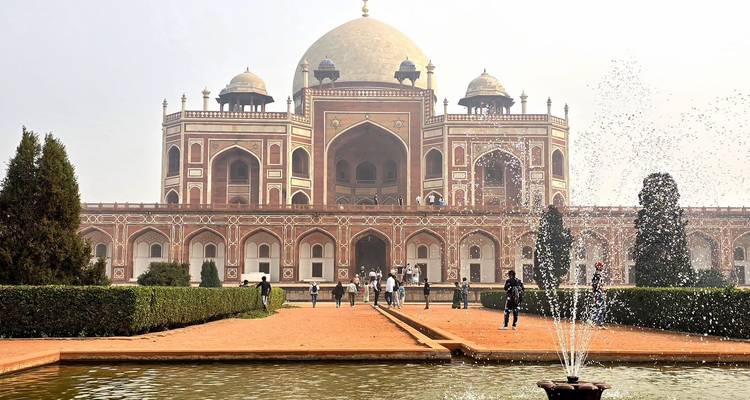 Magnífico monumento histórico rodeado de un jardín y una fuente.