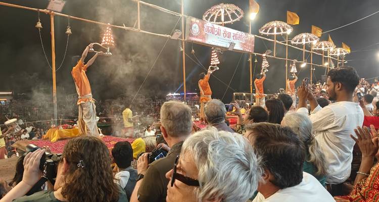 Ceremonia de Ganga Aarti por la noche con muchas personas observando.