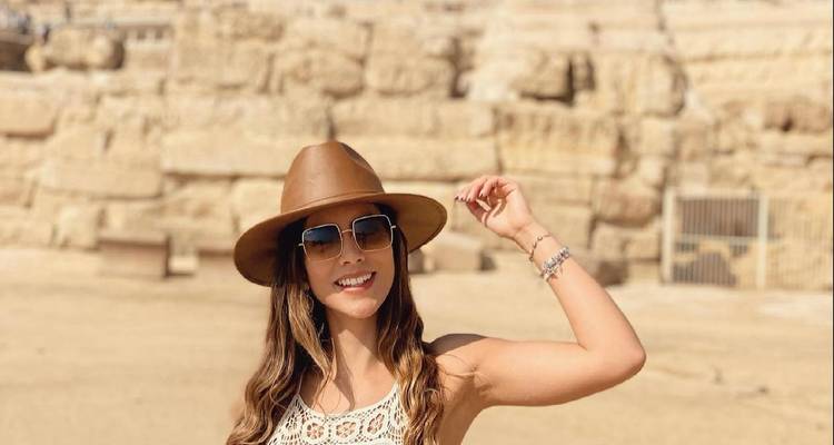 Mujer posando felizmente en un sitio histórico.