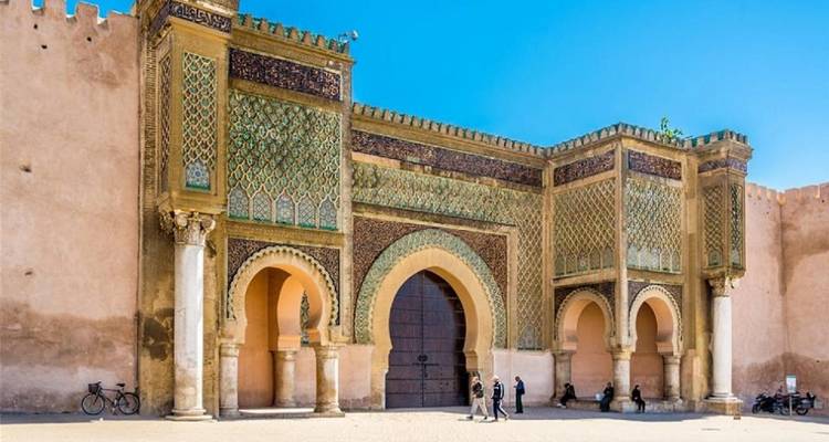 Mausoleo con puerta ornamentada, muros y personas