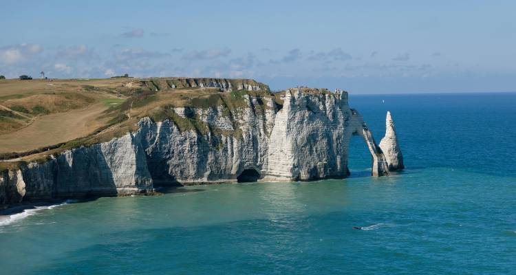 Acantilados blancos de tiza espectaculares y un arco marino de Étretat que se alzan sobre las aguas turquesas del Canal.