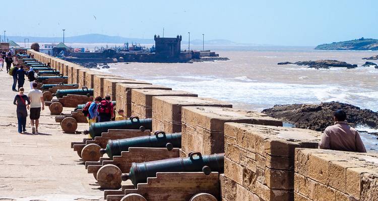 Tourists exploring a historic fort with cannons