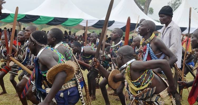 Groep mensen die een traditionele dans uitvoeren met kostuums en stokken.