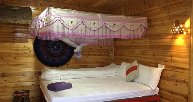 Cama con dosel en una habitación de madera.