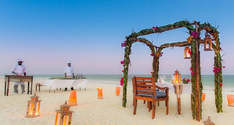 Strandrestaurant-Aufbau mit Laternen und zwei Köchen, die Essen zubereiten.