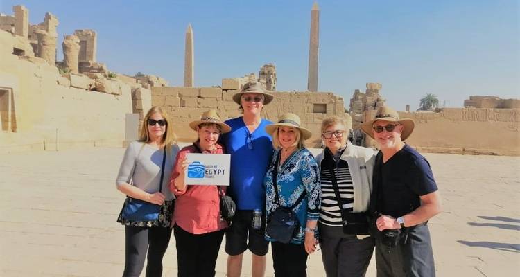 Group of tourists standing in front of an ancient monument.