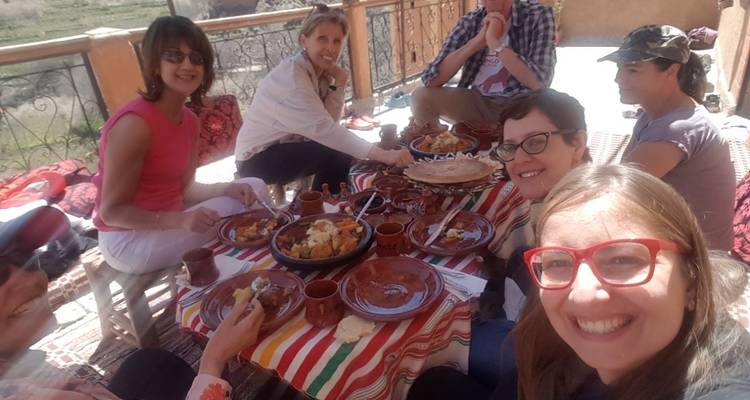 Grupo de personas disfrutando de una comida en una terraza.