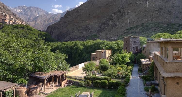 Paisaje montañoso con exuberante vegetación y casas.