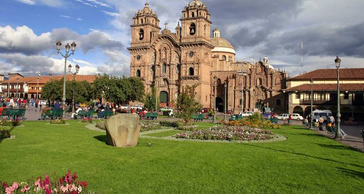 Plaza histórica con una iglesia grande y personas caminando.