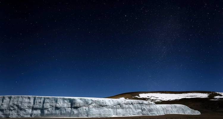 Sternenhimmel über schneebedecktem Plateau.