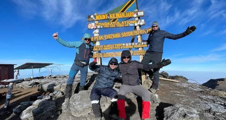 Gruppe feiert auf dem Gipfel des Kilimandscharo.