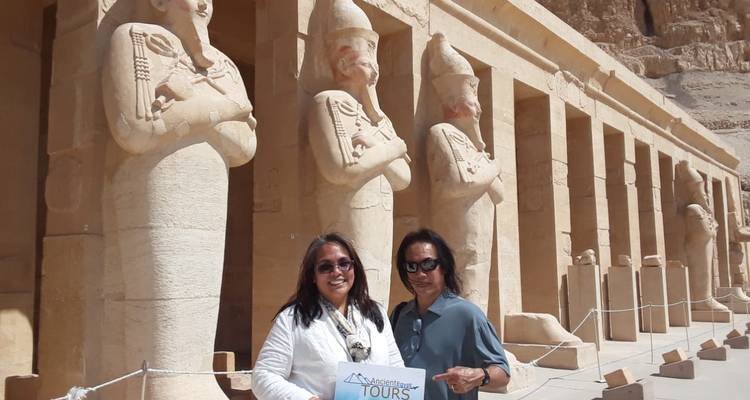 Pareja posando con estatuas en un templo egipcio.