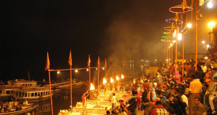 Evening Ganga Aarti ceremony with a crowd on the ghats beside the river.