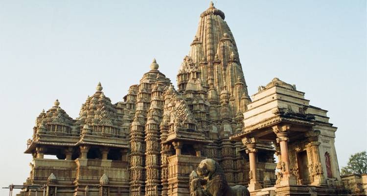 Khajuraho temple with detailed carvings, distinct architectural style.
