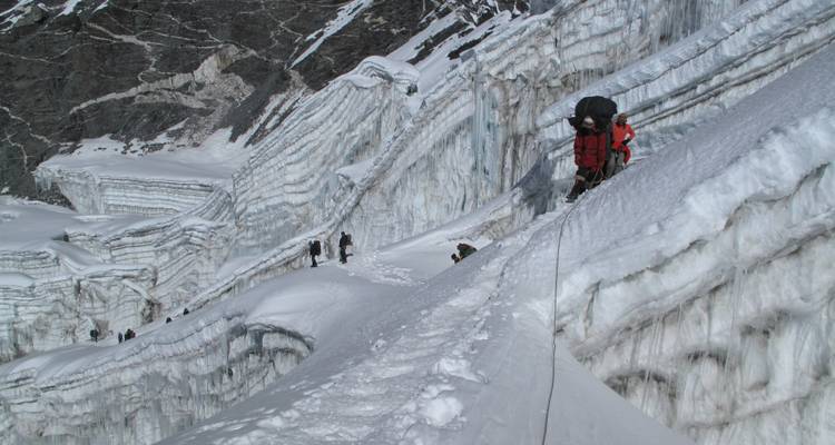 Bergsteiger, die einen schneebedeckten Berggrat erklimmen.