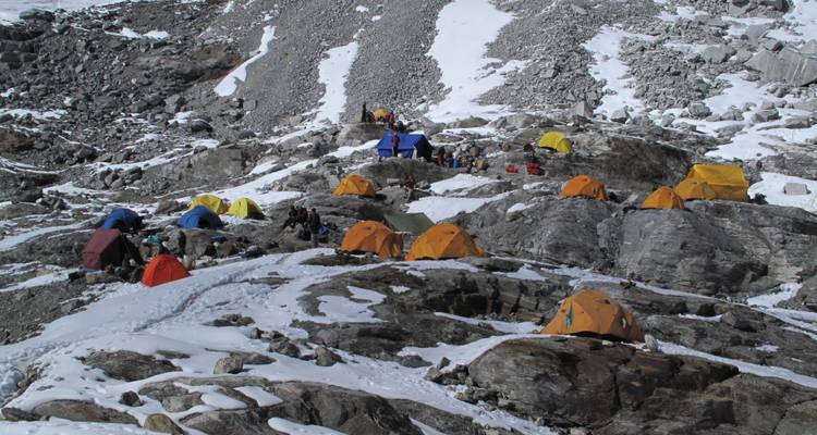 Campingplatz in einer verschneiten Bergregion mit verstreut stehenden Zelten.