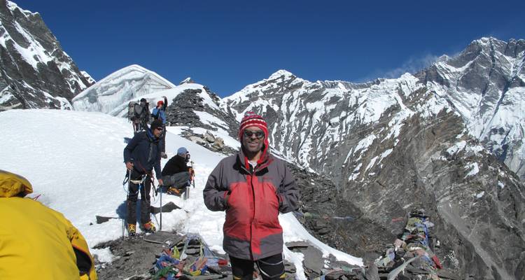 Gruppe von Bergsteigern auf einem verschneiten Grat mit Bergpanorama im Hintergrund.
