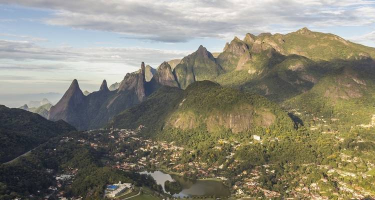 Luchtfoto van een bergachtig landschap met groene valleien en een stad.