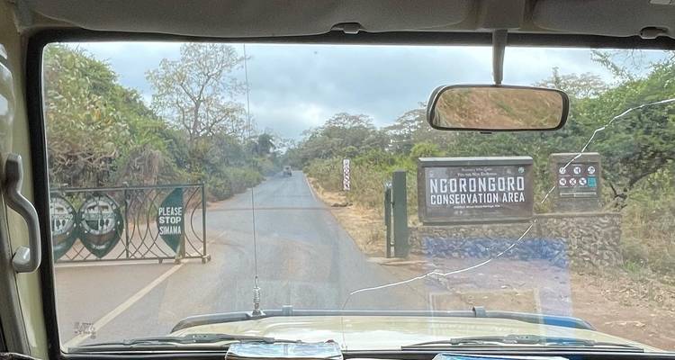 Una vista a través del parabrisas de un vehículo que muestra la entrada del Área de Conservación de Ngorongoro.