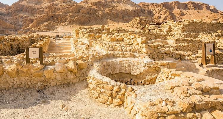 Ancient ruins in a desert landscape with signage.