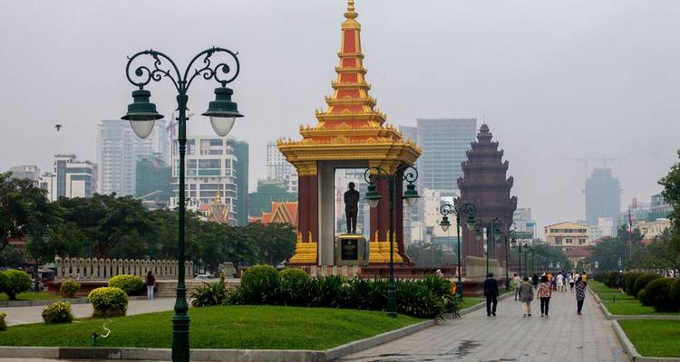 Wide boulevard with Independence Monument and people walking in modern Phnom Penh.