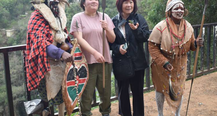 Touristen mit Maasai-Menschen in traditioneller Kleidung in Kenia.