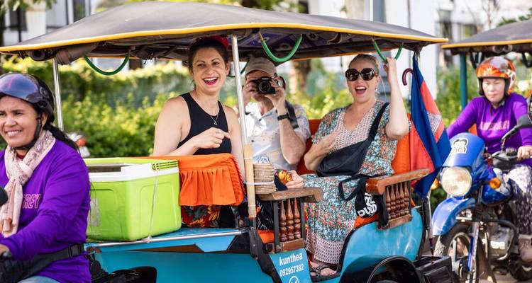 Touristes profitant d'une balade en tuk-tuk, atmosphère joyeuse.