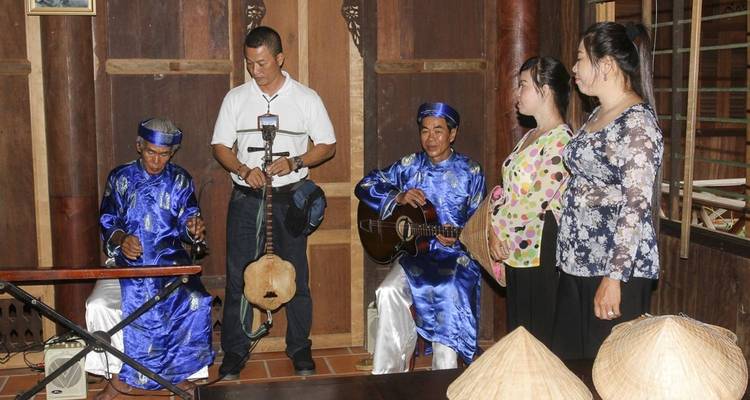 Grupo de personas vistiendo ropa tradicional vietnamita con instrumentos musicales.
