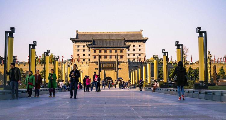 Los visitantes pasean por una amplia avenida que conduce a la imponente puerta sur en lo alto de la muralla antigua de Xi'an.