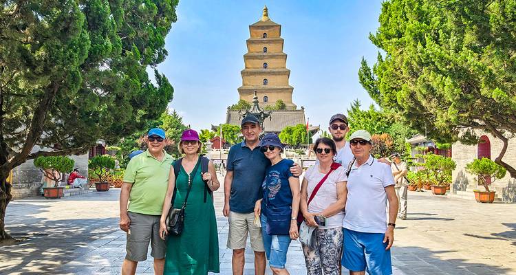 Un groupe de personnes posant devant une grande pagode.