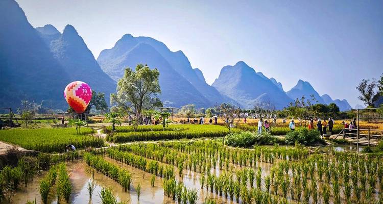El globo aerostático flota sobre arrozales y dramáticos picos de karst en el campo de Yangshuo.