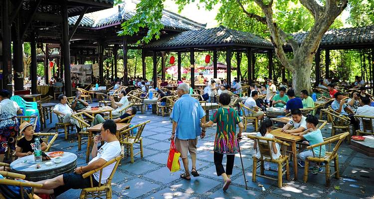 Locals and visitors relax with tea under shady trees in Chengdu’s traditional outdoor teahouse.