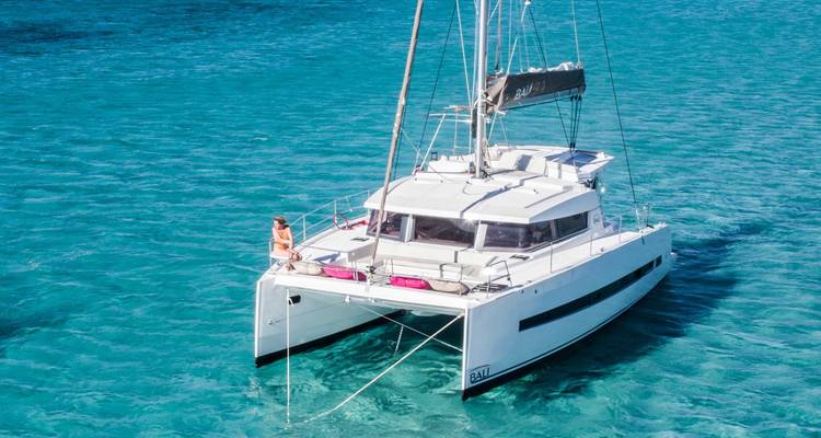 Un catamarán de lujo navegando en aguas azul cristalino.