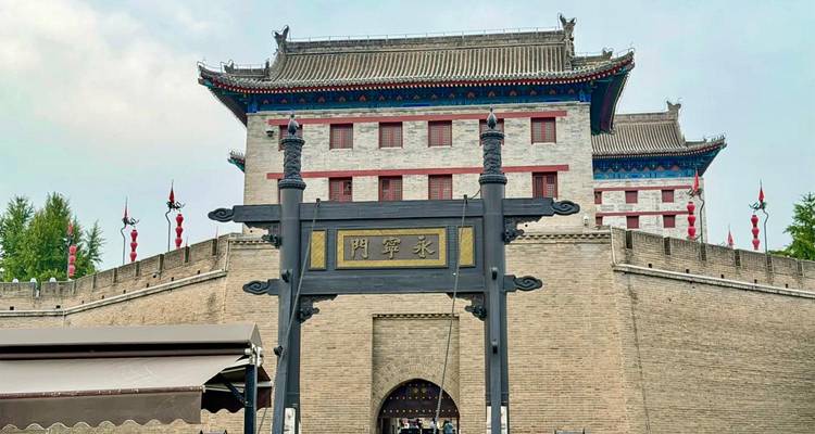 Portail en pierre menant à la Porte Yongning (Sud) de la Muraille de la Ville de Xi'an sous un ciel pâle.