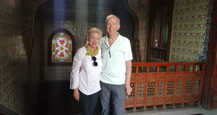 Een paar in een sierlijk versierde kamer met glas-in-lood.