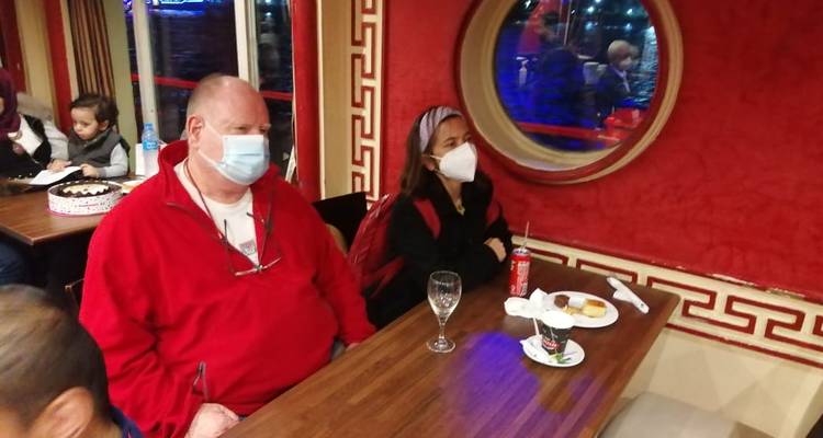 Mensen die in een restaurant zitten met mondkapjes op.