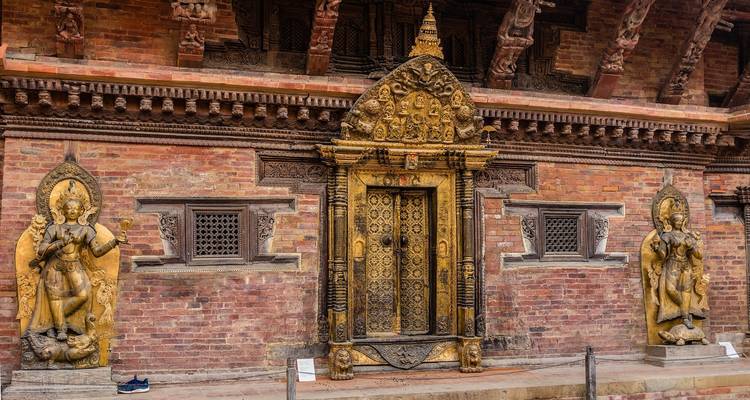 Een sierlijke gouden deur en gedetailleerde bakstenen architectuur.