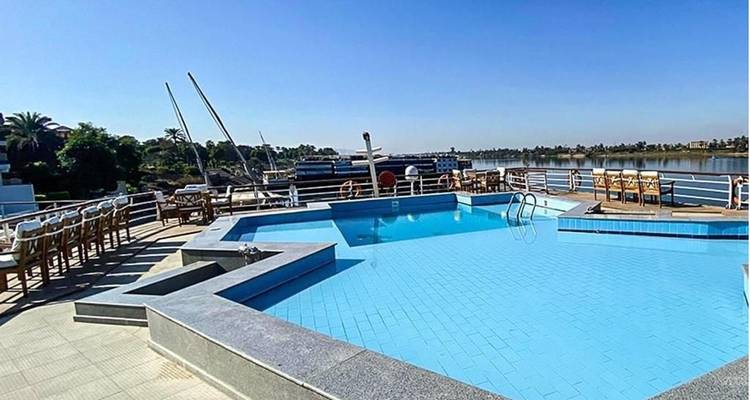 Ein Pool auf einer Terrasse mit Blick auf den Fluss und anliegende Boote.