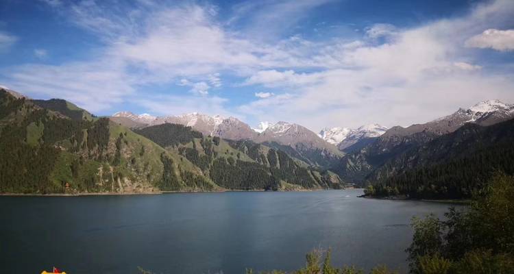 Ein ruhiger See, umgeben von Bergen unter klarem Himmel.