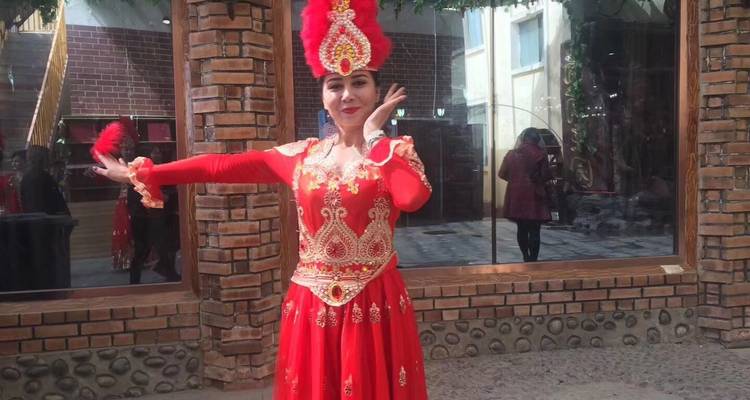 Una mujer con un vestido tradicional rojo realizando una danza cultural.