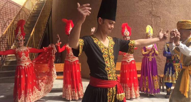 Un grupo de personas con trajes tradicionales realizando una danza al aire libre.