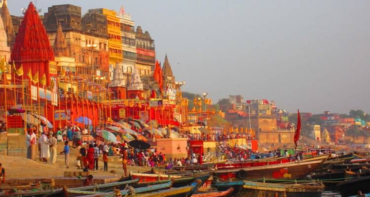 Colorido frente ribereño en Varanasi con muchos barcos y gente.