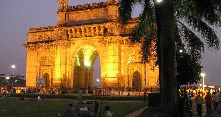 Gateway of India at dusk with people in the foreground.