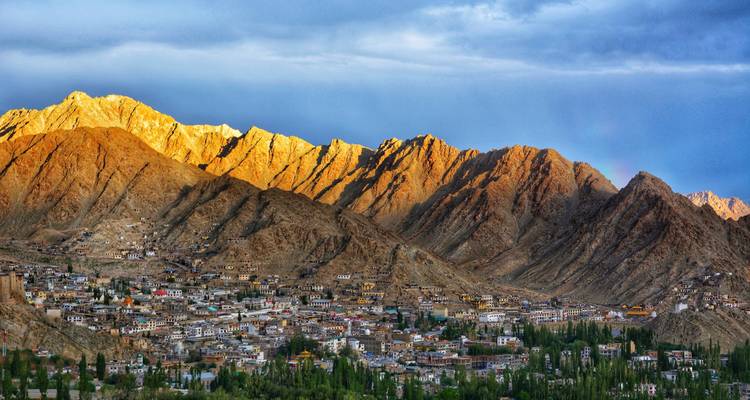 Mountain town with buildings nestled below a mountain range.